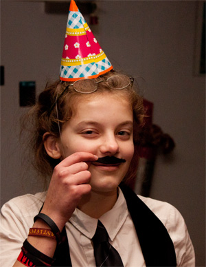 girl with party hat and fake moustache